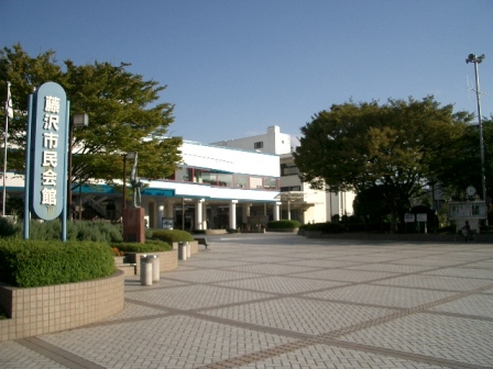 藤沢市民会館全景と案内板を表示しています。