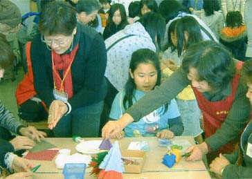 地域(ちいき)の方(かた)から折(お)り紙(がみ)を習(なら)いました。「そうそうその調子(ちょうし)」